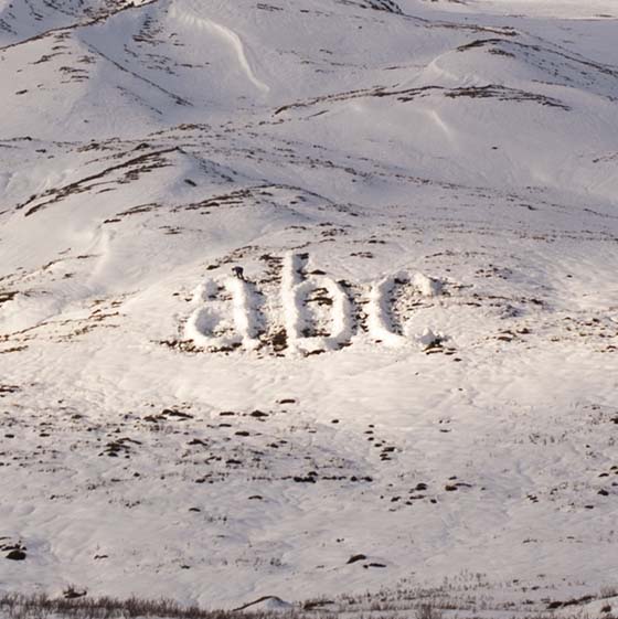 Melt by Michael Cross. Giant letters acb made of smow on a hillside.